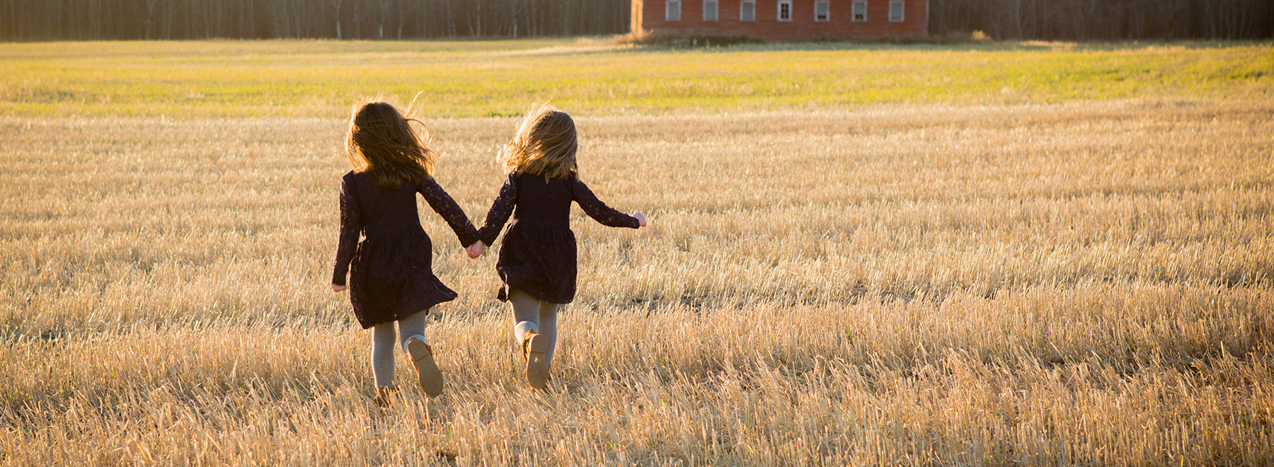two kids walking in a field