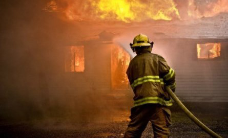 firefighter spraying water on a fire